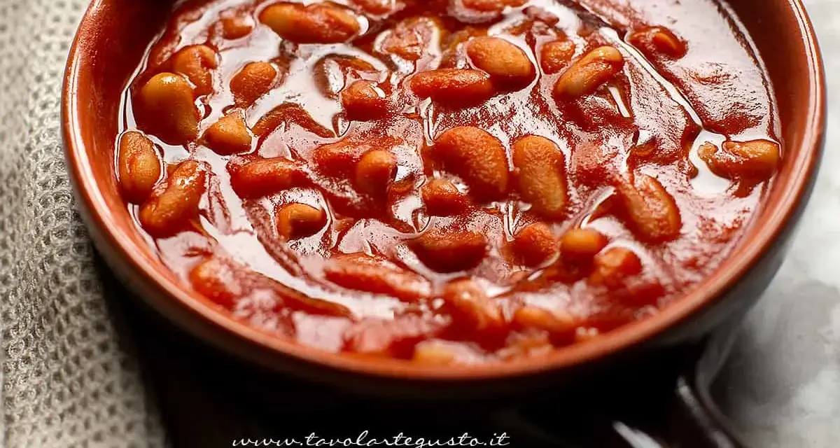 Un primo piano di fagioli all'uccelletto in una ciotola di terracotta, un classico delle ricette italiane.