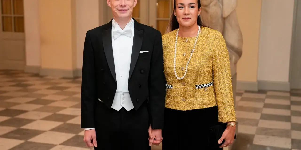 Jonas Vingegaard and his wife, Trine Marie, dressed formally for an event. He wears a tuxedo, and she sports a yellow tweed jacket and pearl necklace.