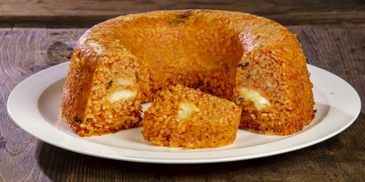 Un invitante timballo di riso, dorato e ripieno di formaggio filante, pronto per essere gustato.
