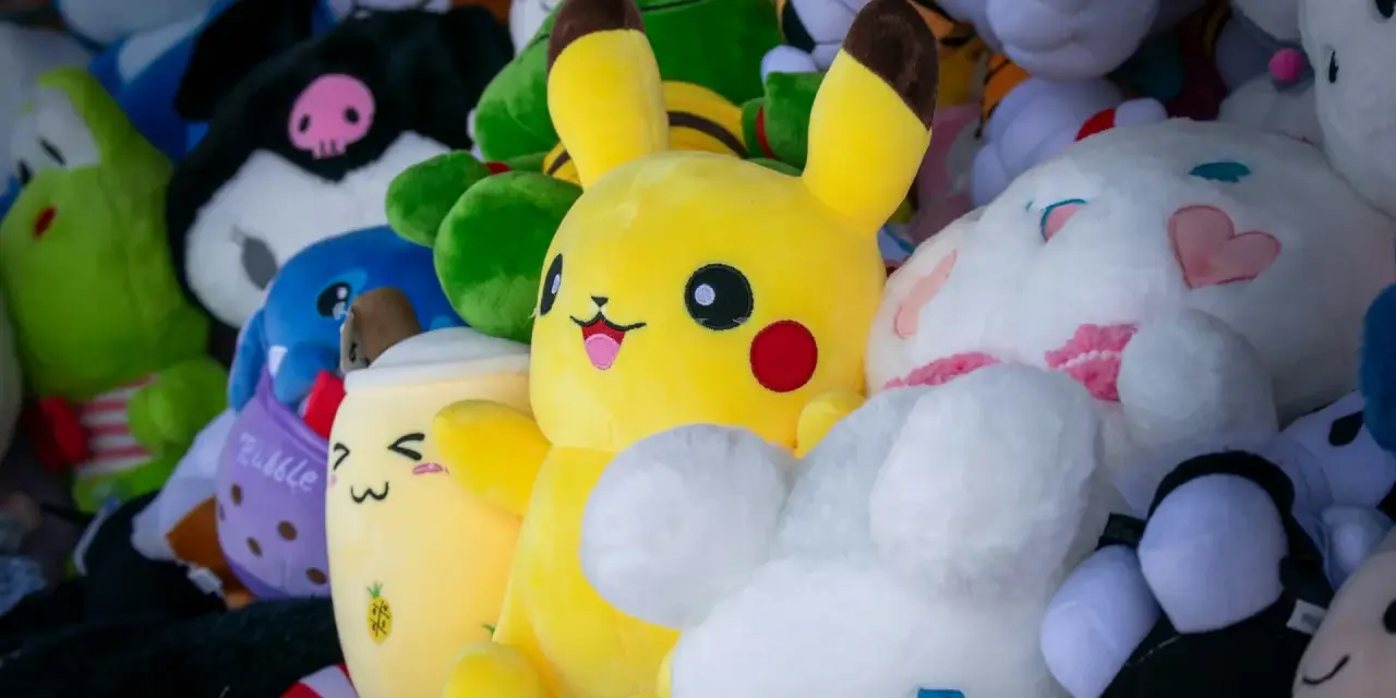 Pluszaki, jak Pikachu i króliczek, czekają na pranie. Kolorowe, miękkie zabawki w różnych kształtach.