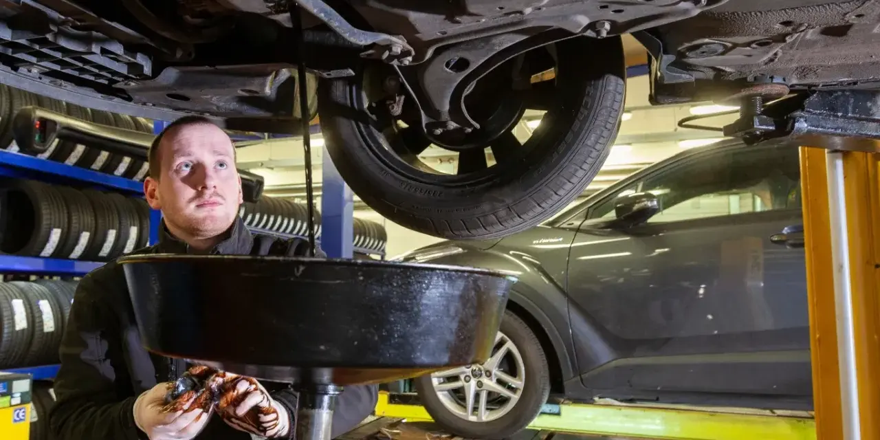 Mechanik spuszcza zużyty olej z samochodu. Zastanawiasz się, ile trwa wymiana oleju i filtrów?