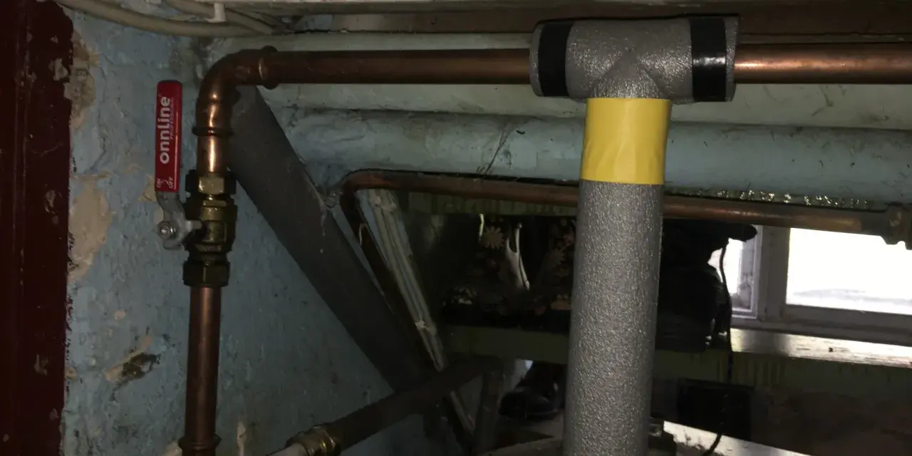 Kopparrör med isolering och en röd ventil, redo att fylla på luft i hydrofor.