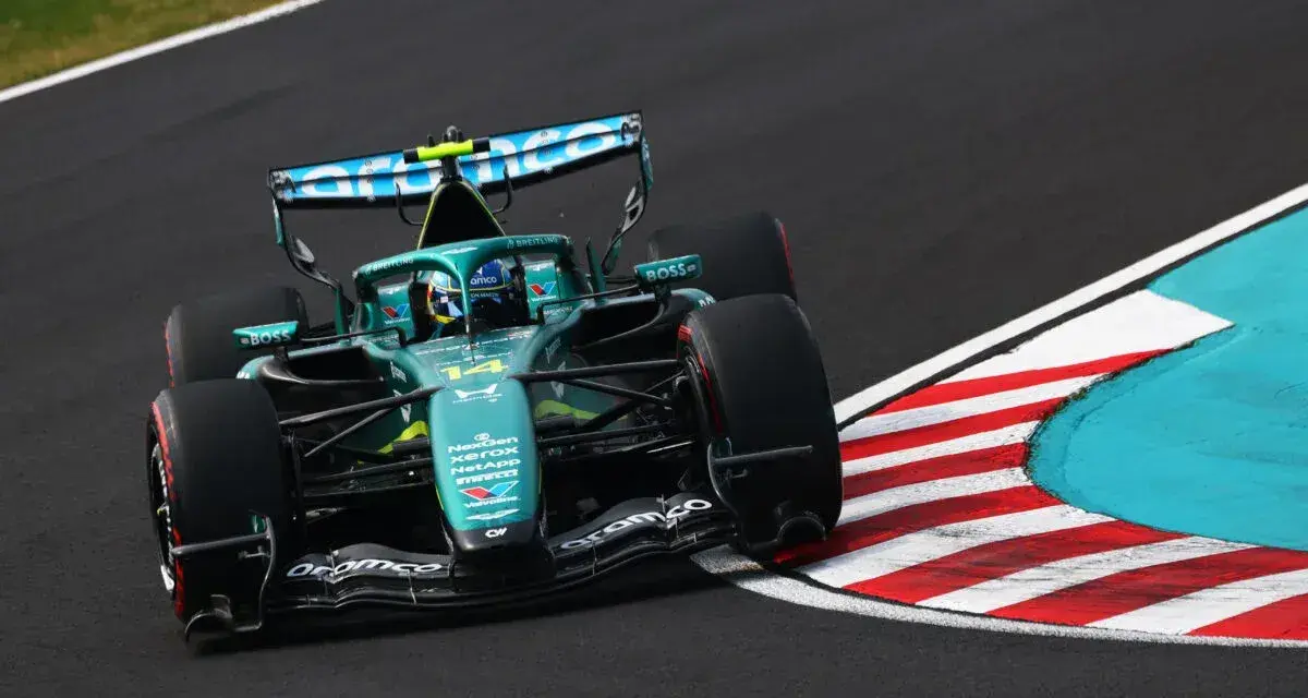 El coche Aston Martin F1, con el número 14, acelera en una curva.