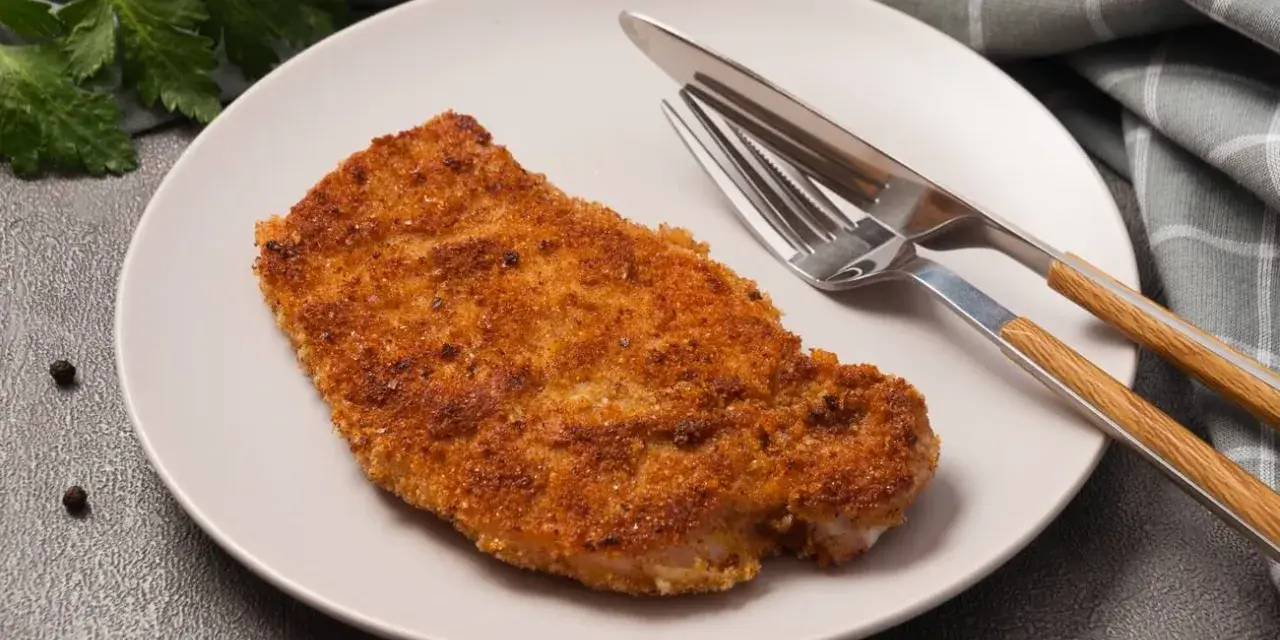 Złocisty kotlet schabowy na talerzu, gotowy do zjedzenia. Zastanawiasz się nad kotlet schabowy kcal?