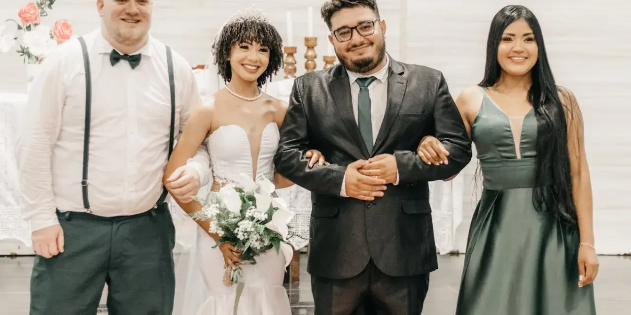 Sposi con due testimoni, un uomo e una donna, sorridono felici. Il rito civile quanti testimoni? Due sono sufficienti per suggellare l'amore.