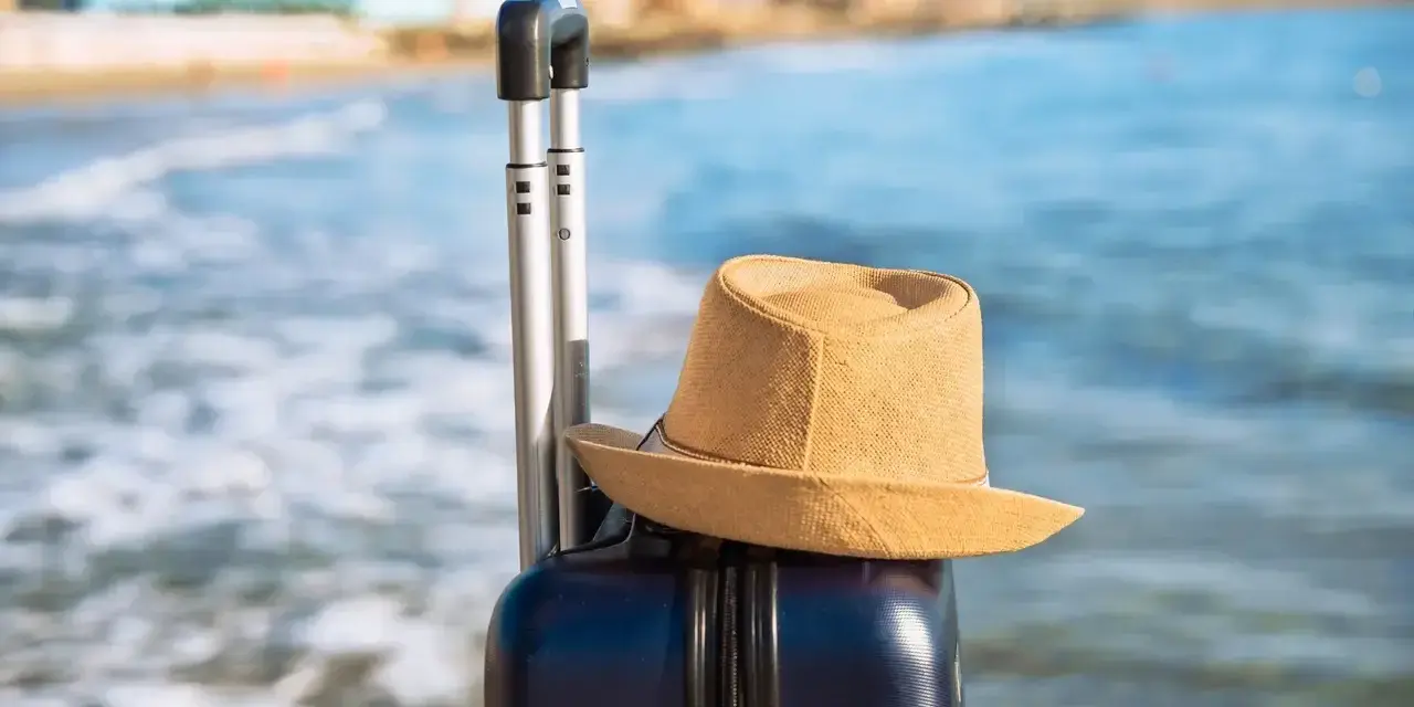 Walizka i kapelusz na plaży. Idealna pogoda w Bułgarii w październiku na ostatnie chwile lata.