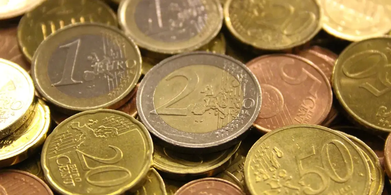 Gros plan sur une pile de pièces en euros de 2002. On distingue des pièces de 1 euro, 2 euros, 20 centimes et 50 centimes.
