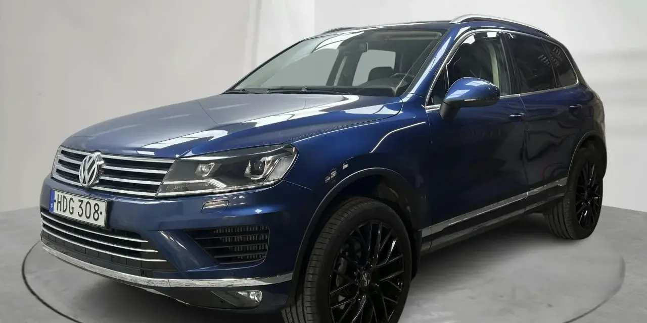 Blå VW Touareg med svarta fälgar. En bil med ett potentiellt vw touareg problem, står på en snurrplatta i en studio.