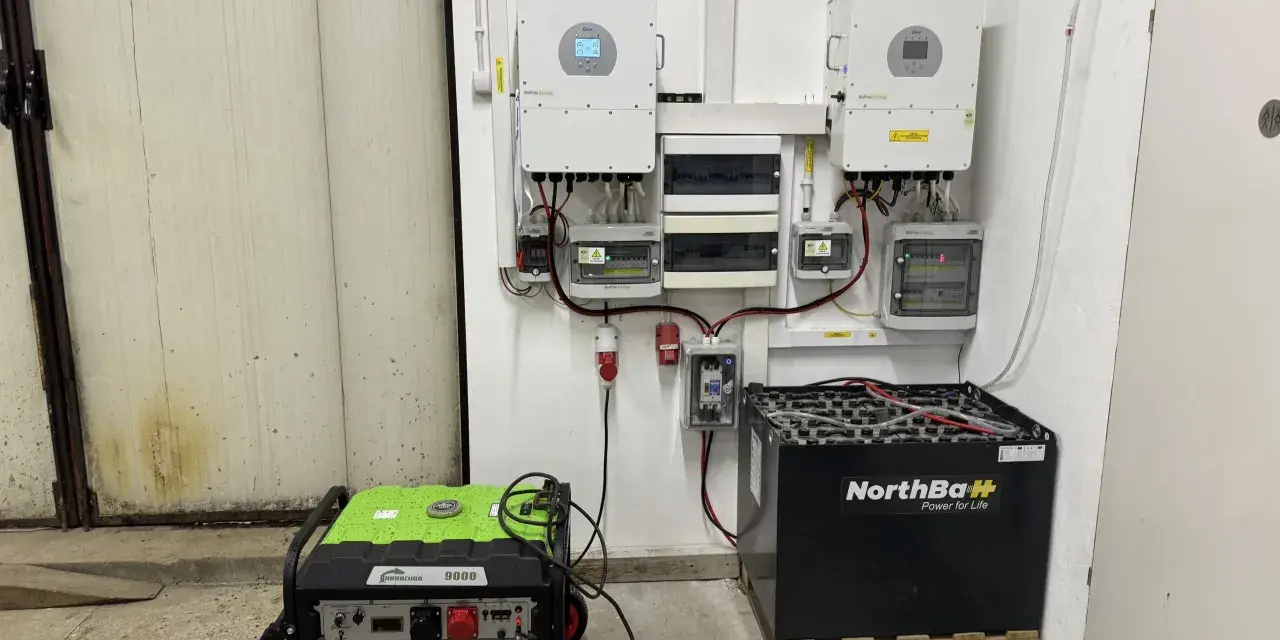 Instalacja fotowoltaiczna z falownikami, akumulatorami i agregatem prądotwórczym. System zapewnia niezawodne zasilanie.