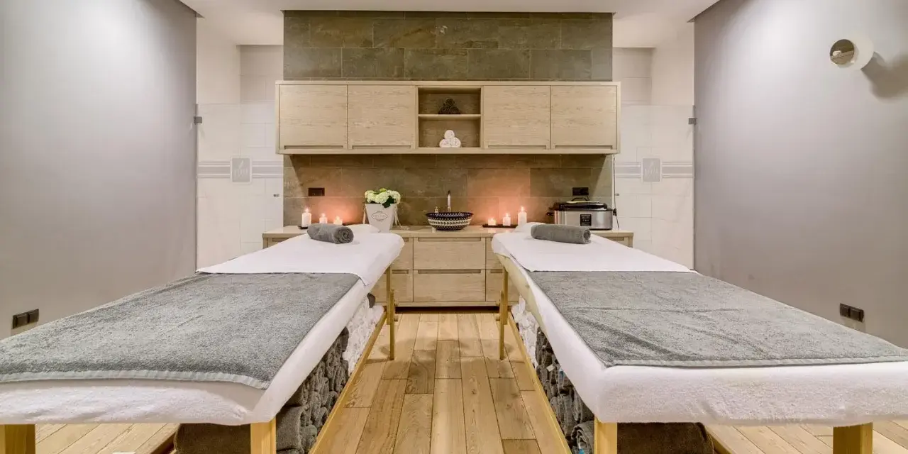 Dwie leżanki do masażu, świece i kwiaty tworzą atmosferę relaksu. Idealne miejsce na 2-dniowy pobyt w spa dla dwojga.