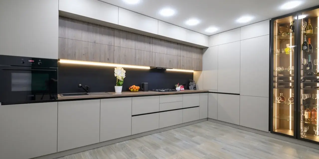 Cocina moderna con armarios grises y vitrina iluminada. El suelo de madera clara es perfecto para suelos para cocinas sin obras, aportando calidez y estilo.