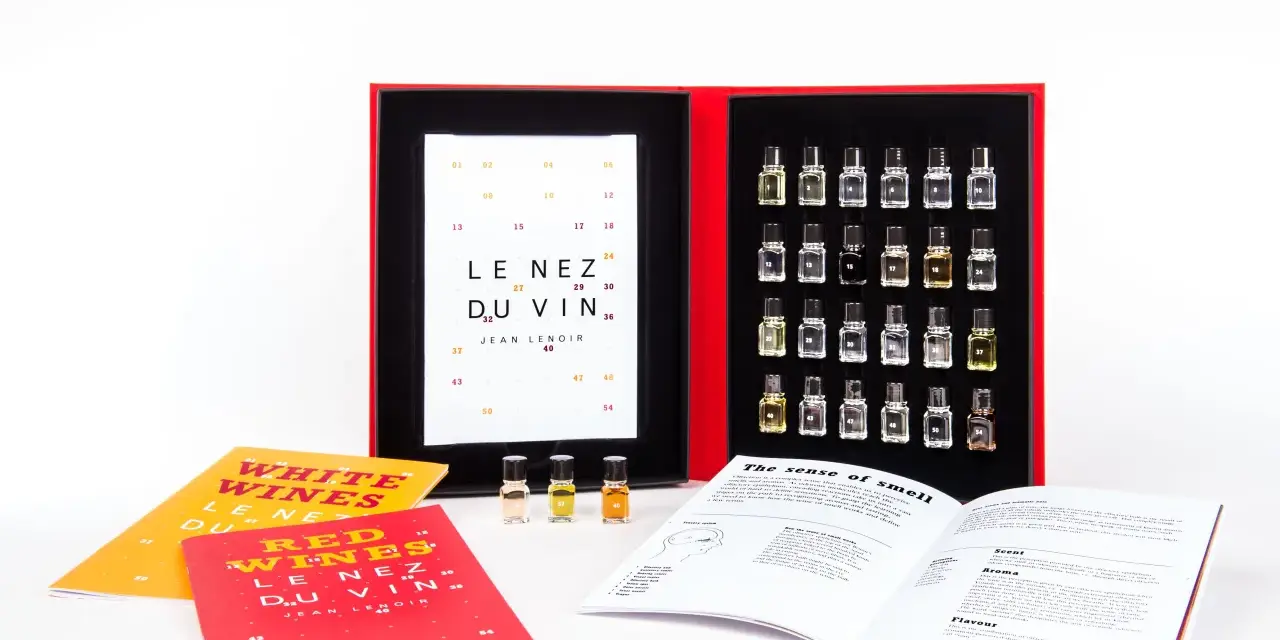 Kit de degustación "Le Nez du Vin" con pequeños frascos de aromas, libros y una tabla de cata.