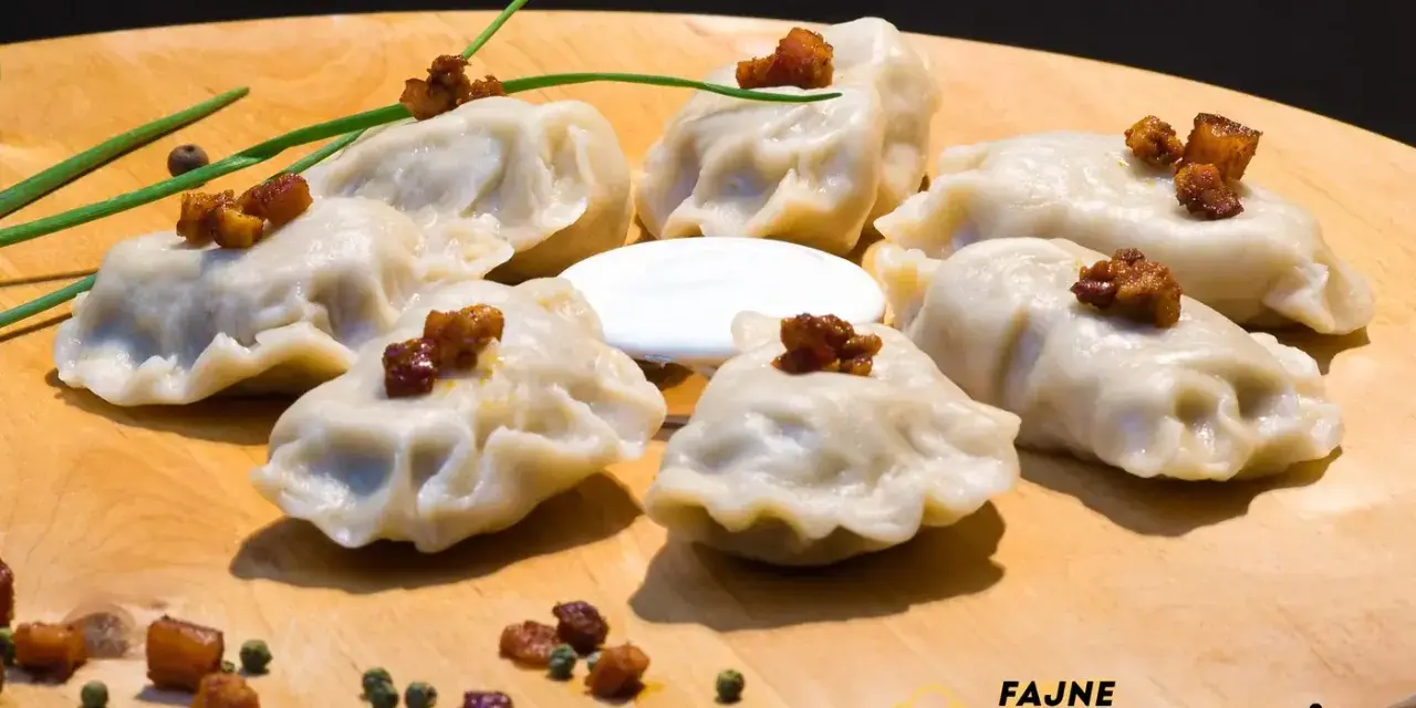 Pyszne pierogi ruskie kontra pierogi z mięsem, podane na desce z chrupiącym skwarkami i śmietaną.