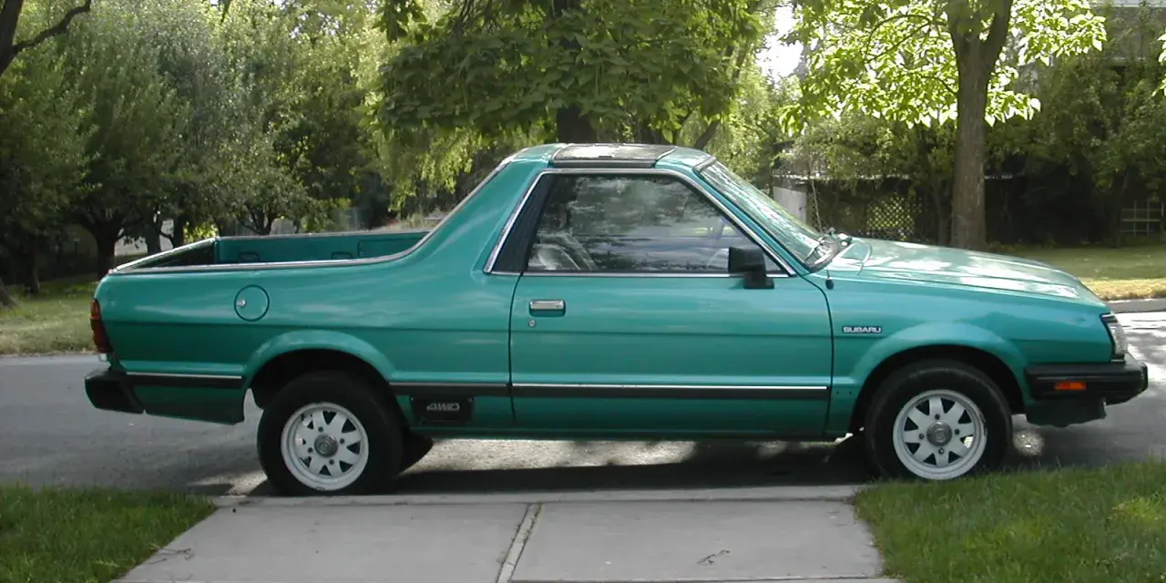 Zielony Subaru Brat z lat 80. stoi na podjeździe, gotowy na przygodę.