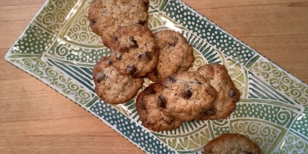 Leckere sauerteig cookies mit Schokoladenstückchen auf einer grünen, gemusterten Platte.