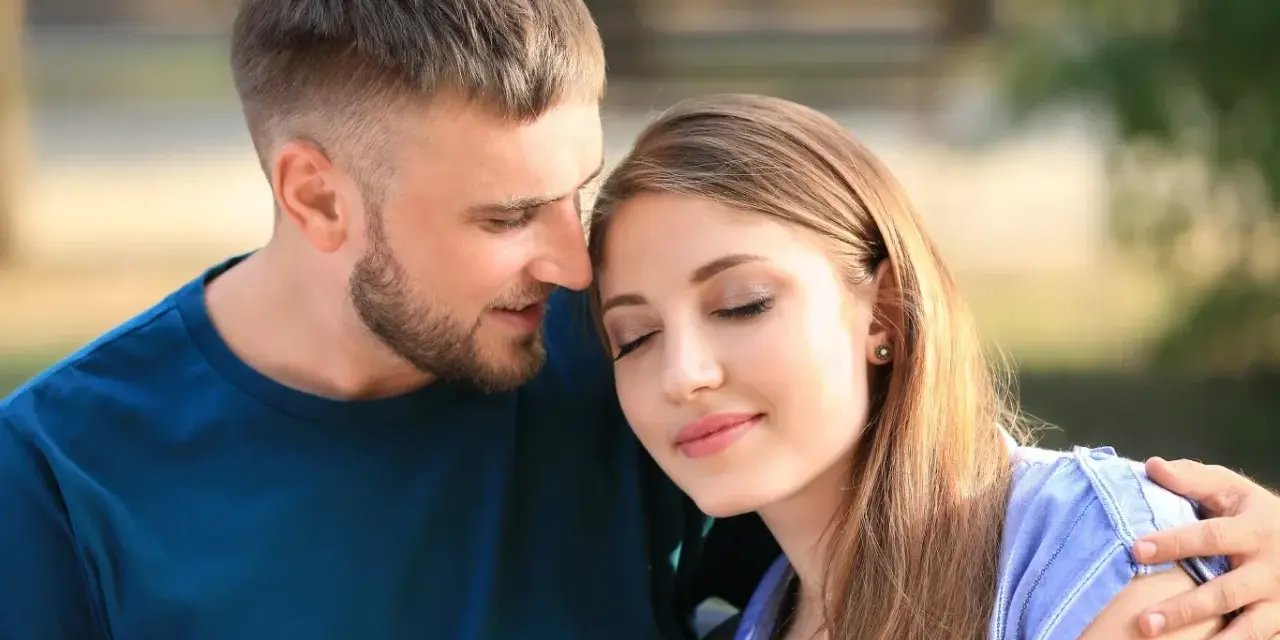 Mężczyzna z zarostem obejmuje kobietę, która opiera głowę na jego ramieniu. Wyglądają na zakochanych, idealny partner dla barana.