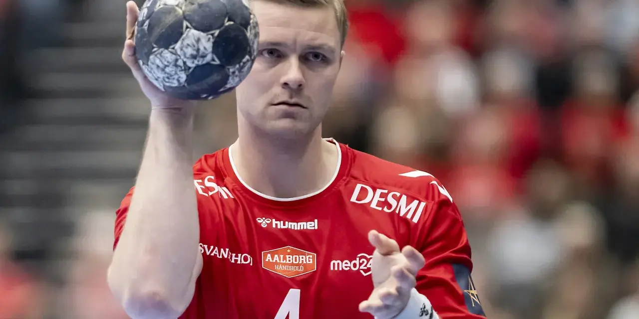 Aron Palmarsson, zawodnik z numerem 4 na czerwonej koszulce, trzyma piłkę do piłki ręcznej, gotowy do rzutu.