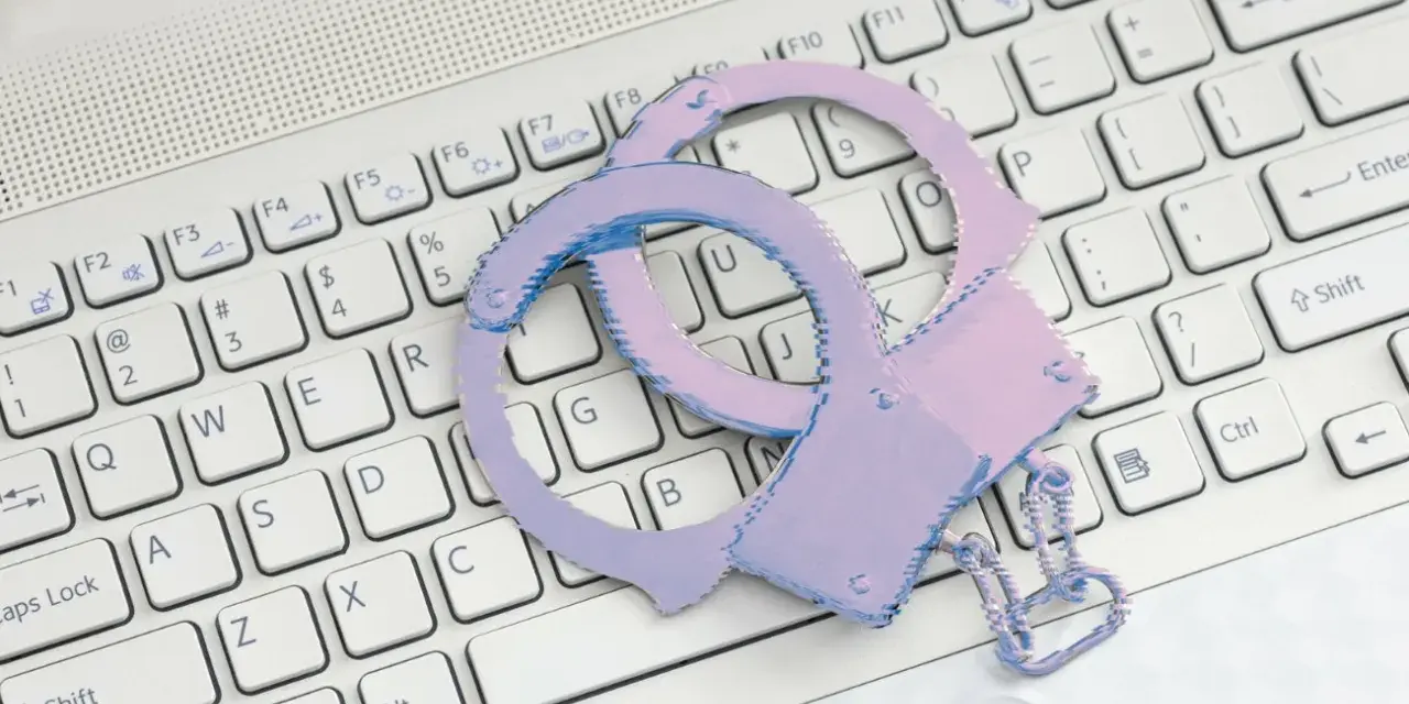 Różowe kajdanki na klawiaturze laptopa symbolizują problemy ze sklepem z aplikacjami.