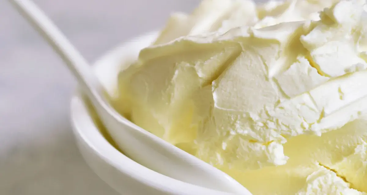 Kremowa masa w białej miseczce, idealna jako zamiennik mascarpone do deserów.