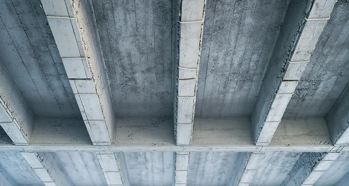 Betonowy strop z widocznymi belkami i płytami. Szukając, jaki strop najtańszy, warto rozważyć takie proste konstrukcje.