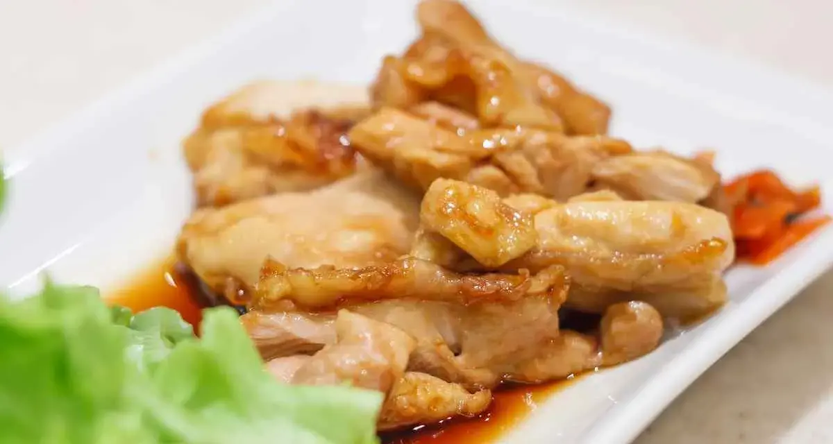 Straccetti di pollo succulenti in salsa agrodolce, serviti con insalata fresca e carote.