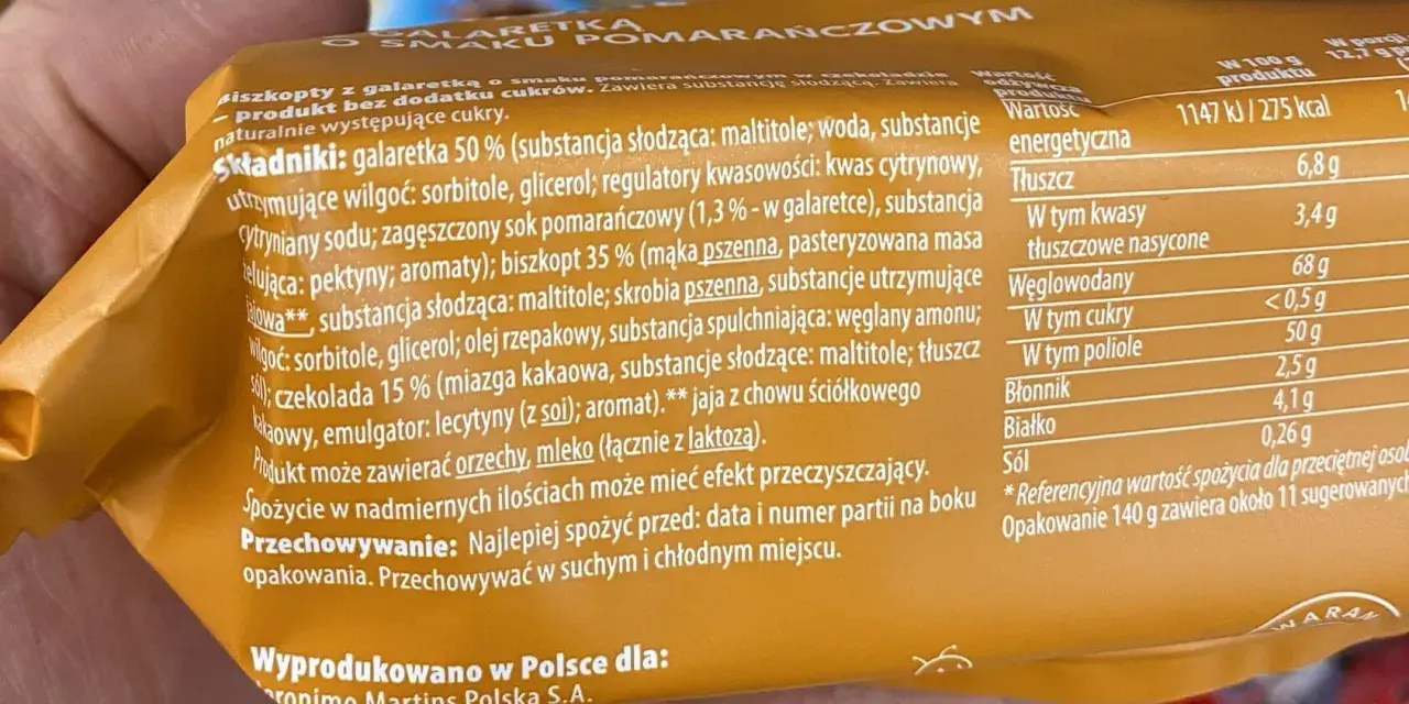 Pomarańczowe delicje kcal: biszkopt z galaretką i czekoladą. Na opakowaniu podano składniki i wartości odżywcze, w tym 275 kcal na 100g.