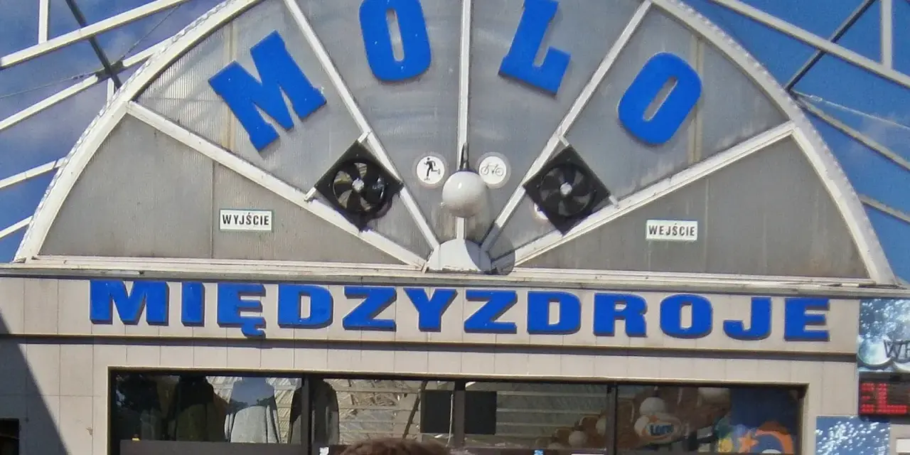 Napis "MOLO" i "MIĘDZYDROJE" na budynku, który może być częścią Alei Gwiazd w Międzyzdrojach.