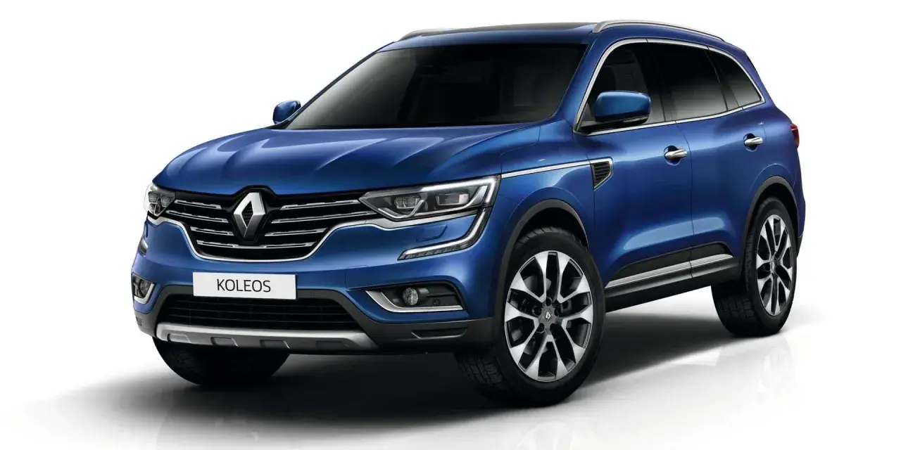 Niebieski Renault Koleos II, który może mieć pewne **awarie i problemy**, prezentuje się elegancko na białym tle.