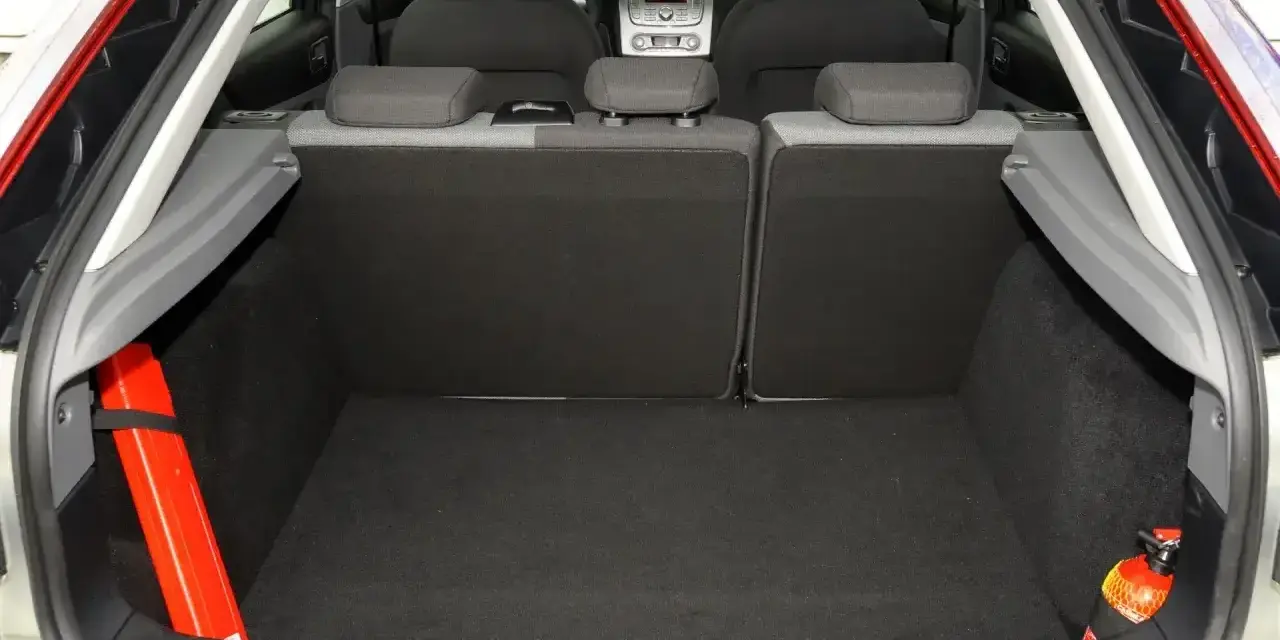 Bagażnik Ford Focus MK2 1.6 TDCI gotowy na podróż. Widoczne siedzenia, apteczka i gaśnica.