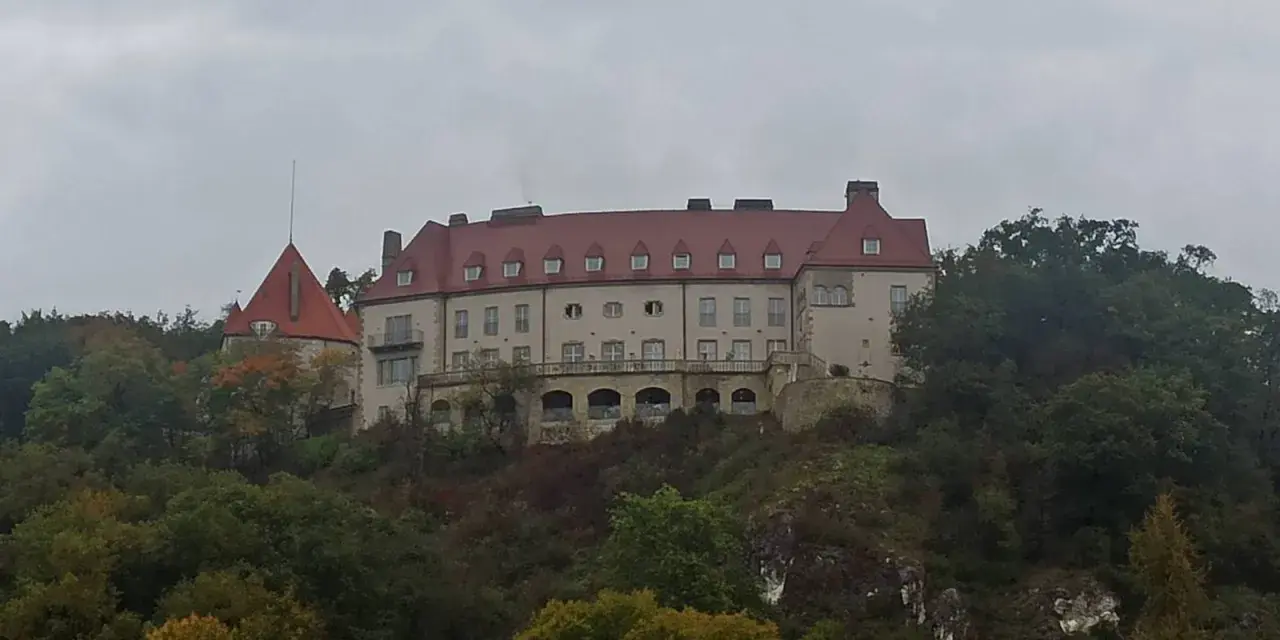 Zamek na wzgórzu, otoczony jesiennym lasem, przypomina o historii Krakowa i Kalwarii Zebrzydowskiej.
