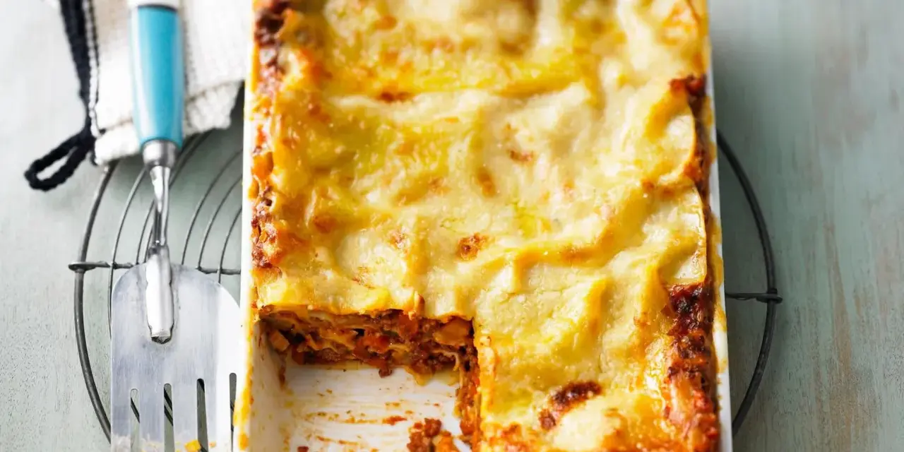 Herzhaftes Lasagne Rezept mit goldbrauner Käsekruste, bereit zum Servieren. Ein Stück fehlt bereits!