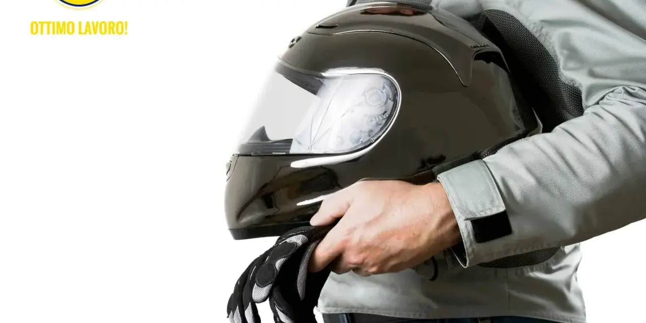 Un motociclista tiene un casco nero lucido e guanti. Scopri come pulire visiera casco per una guida sicura.
