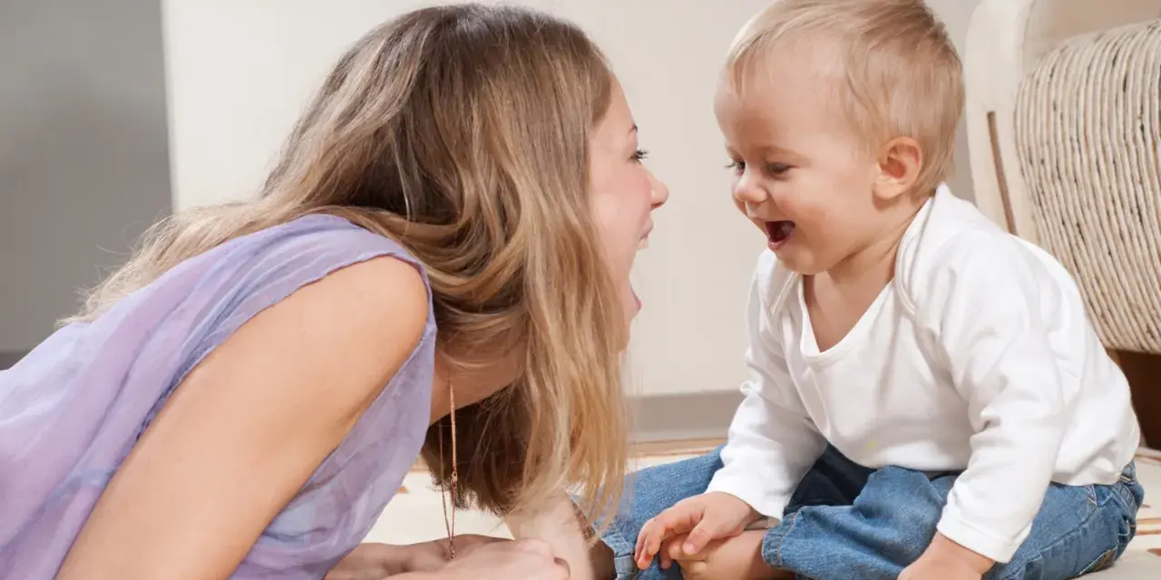 Frau und Baby lachen sich an. Sie unterhalten sich, zahlen ohne Sorgerecht, aber die Freude ist echt.