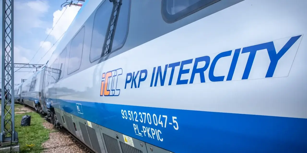 Pociąg PKP Intercity z niebieskim pasem i logo.