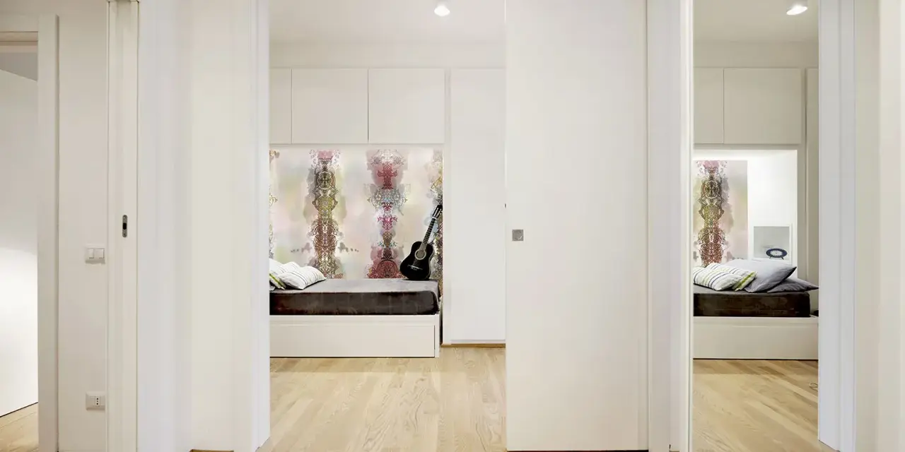 Un letto a scomparsa e una porta scorrevole creano una stanza in più, trasformando un corridoio in uno spazio accogliente.
