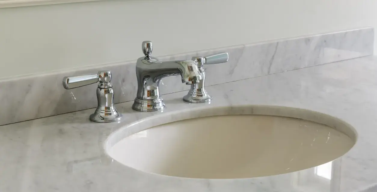 Lavandino in marmo poroso con rubinetteria cromata. Per sapere come pulire il marmo poroso, guarda questo bagno elegante.