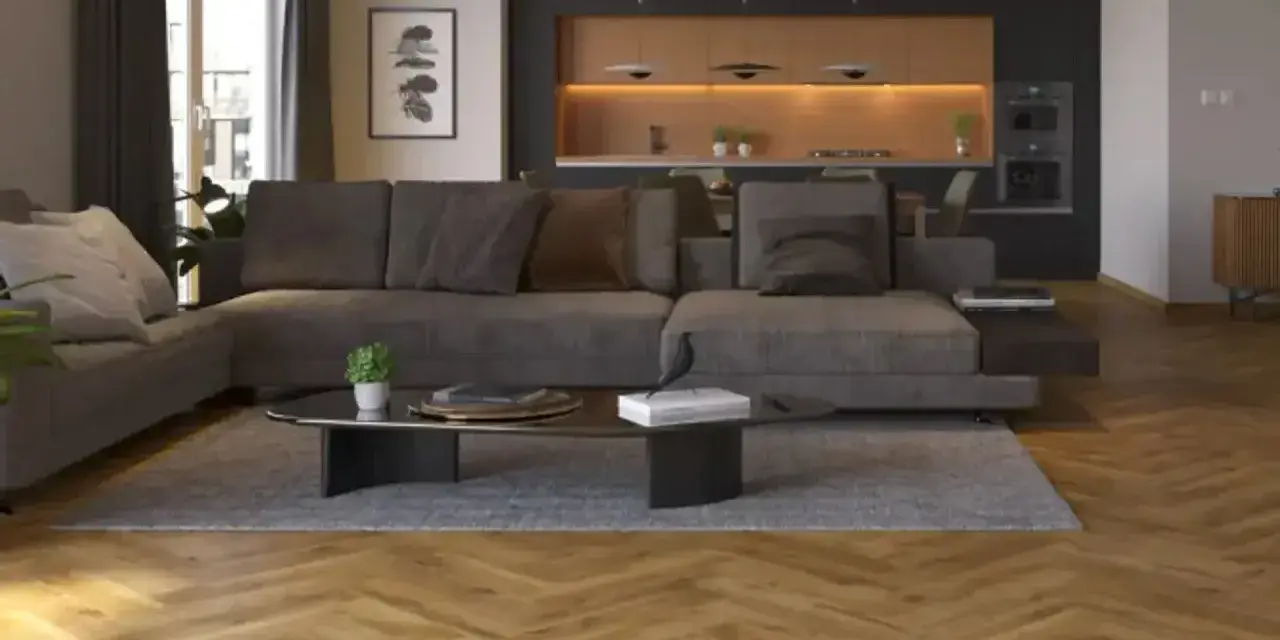 Nowoczesny salon z szarą kanapą i czarną ścianą w tle. Drewniana podłoga w jodełkę dodaje ciepła.