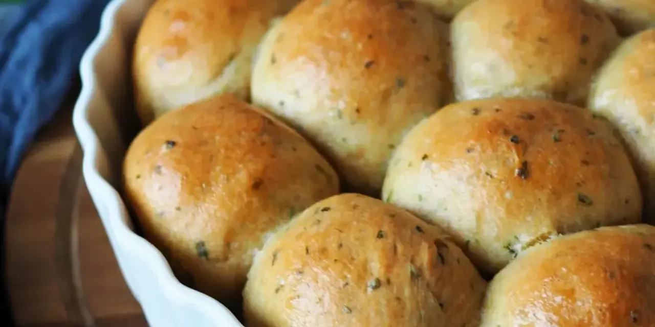 Frisch gebackene, goldbraune Brötchen mit Kräutern, bereit zum Genießen. Ein perfektes kleines Brot backen für jeden Anlass.
