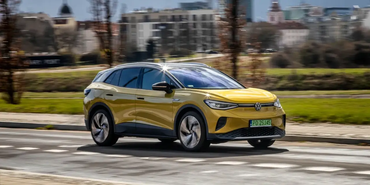 Żółty VW ID.4 jedzie po mieście, pokazując swój imponujący zasięg.