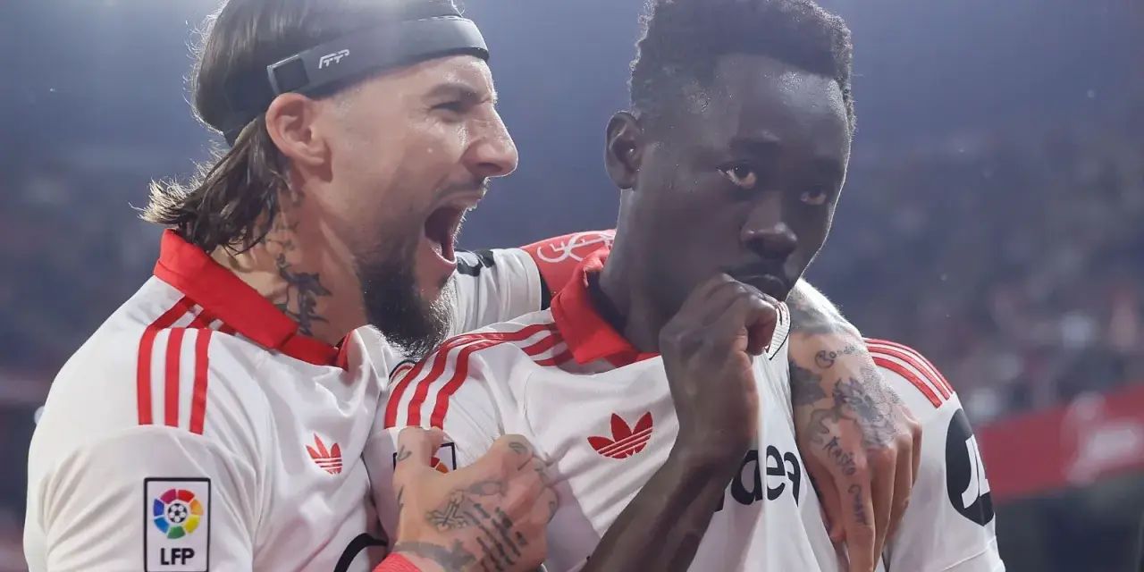 Jugadores del Sevilla FC celebran un gol contra el Atlético de Madrid. Uno grita con euforia, el otro reflexiona.