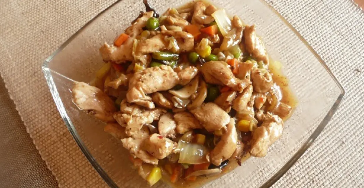 Pyszny kurczak w 5 smakach z warzywami w sosie, podany w szklanej misce.