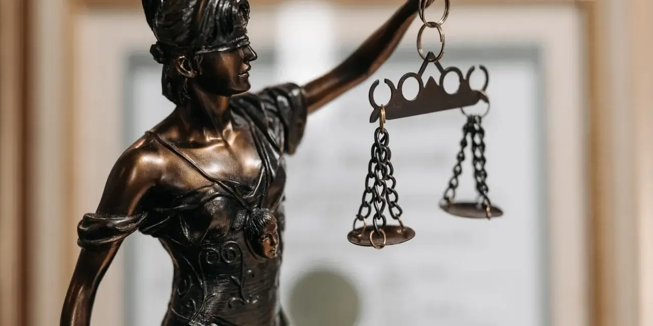 Statua della Giustizia con bilancia, simbolo di chi ha conseguito la laurea in legge o giurisprudenza.
