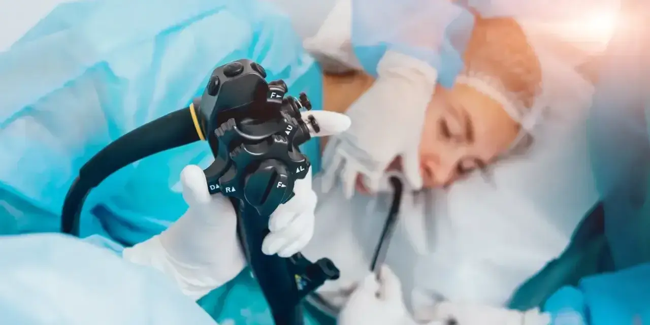 Gastroskopia ze znieczuleniem w toku. Lekarz trzyma endoskop, przygotowując się do badania pacjenta.