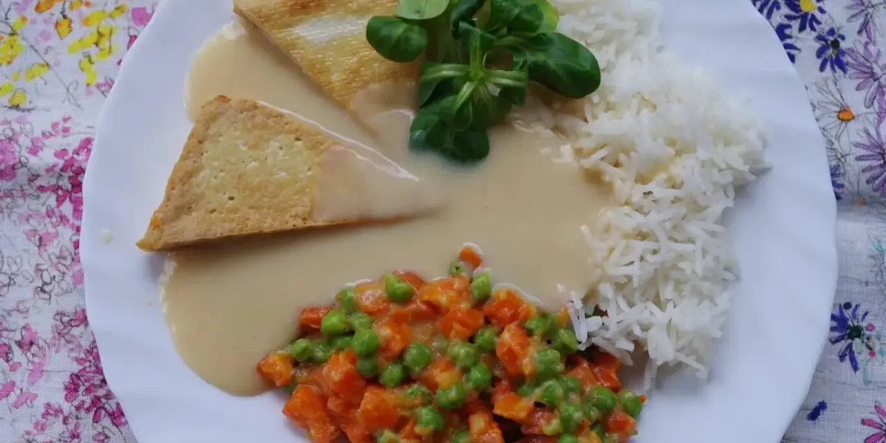 Trójkątne kawałki tofu w kremowym sosie madras, podane z ryżem i warzywami.