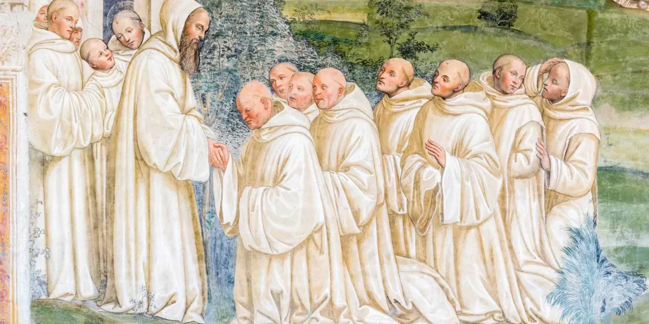 A bearded monk greets a line of novices, their white robes hinting at a rich monk history.