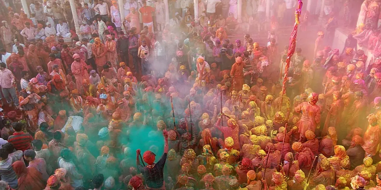 Tłum ludzi w kolorowym pyle podczas festiwalu Holi. To jedno z wielu barwnych festiwali na świecie, pełne radości i tradycji.