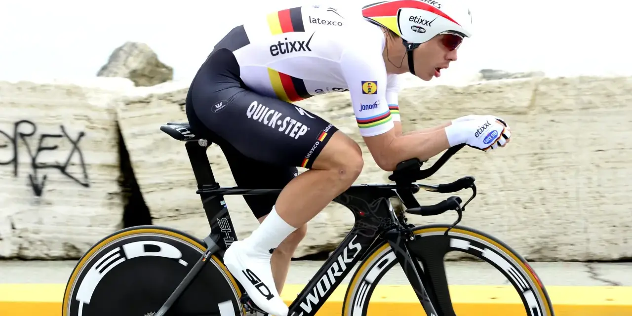 Cyclist in full aerodynamic gear, focused on time trial training, pushing hard on a specialized bike.