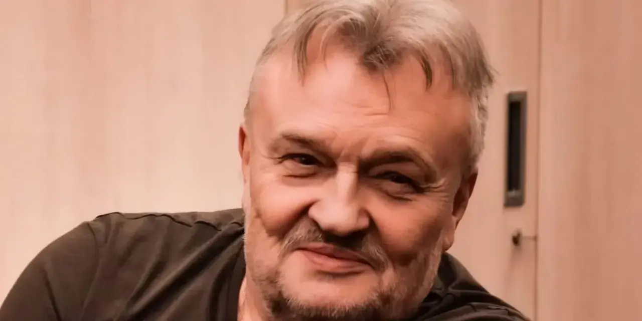 Uśmiechnięty Krzysztof Cugowski, z siwiejącymi włosami i zarostem. Zastanawiasz się, ile lat ma Krzysztof Cugowski?