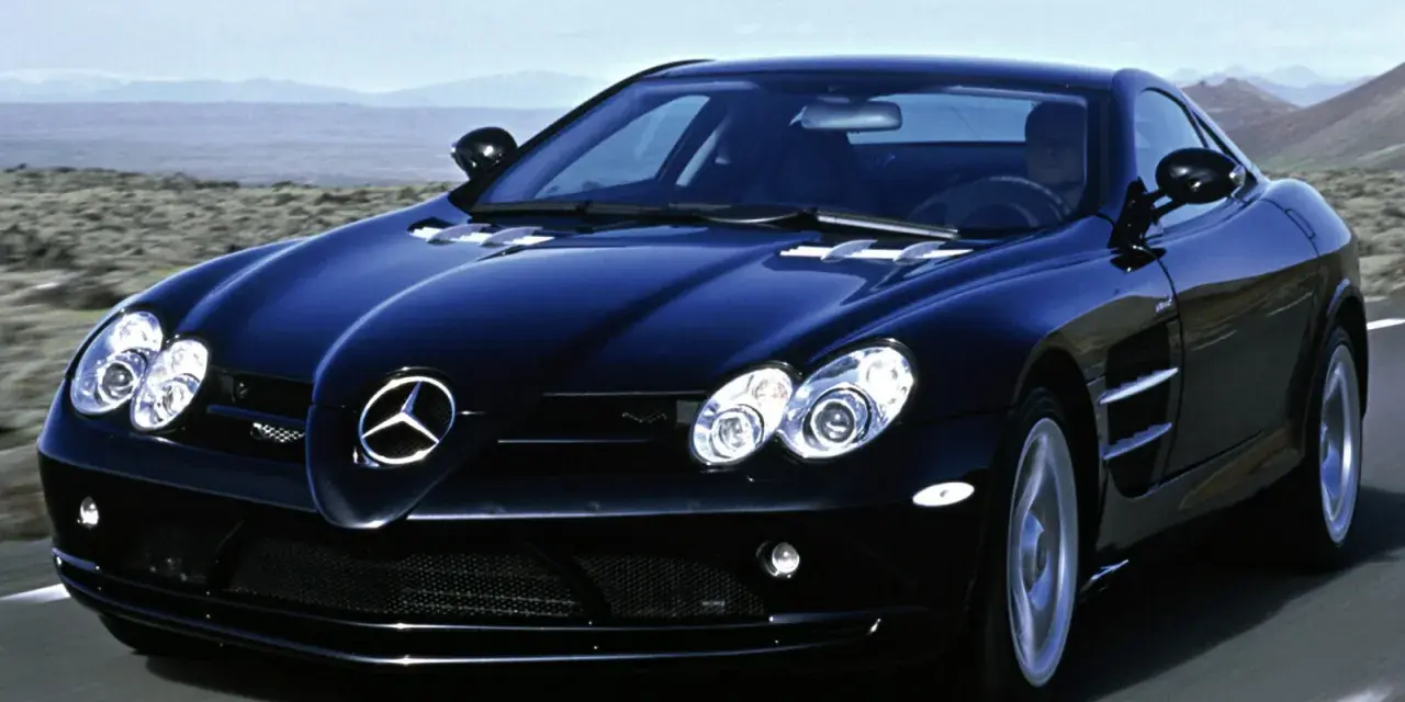 Czarny SLR McLaren pędzi po pustynnej drodze, jego sylwetka lśni w słońcu.