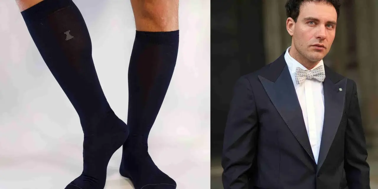 Un uomo elegante con smoking e papillon abbinato a calzini scuri.